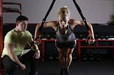 A personal trainer working closely with a woman
