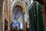 Looking through a row of arches into the distance with a blue and white globe suspended