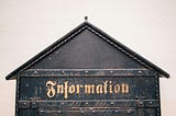 A metal house that has “information” written on the front.