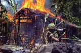 A US Marine walks away after burning a suspected VC Encampment