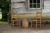 Two chairs with a checkerboard on a barrel.