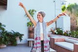 Woman Laughing while Raising Her Both Arms