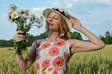 Dreamy woman with flowers in field.