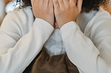 young boy covering his face shamefully