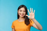 Asian woman holding up five fingers.