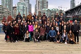 Team Thinkific poses on a dock at Vancouver’s Granville Island on a cloudy day during a quarterly team wide celebration.