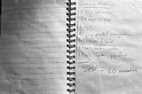 a black and white photo of a handwritten recipe for banana muffins on a worn page of a spiral notebook