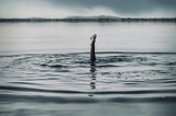 Hand Stretching Out Of The Middle Of The River