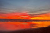 Burning red sunset on a beach in Lisbon.
