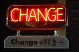 CHANGE in neon signage above a Change sign with money icons, likely some kind of change making machine