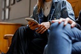A student is holding a phone and talking to a friend