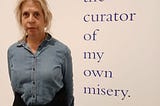 Picture of the author considering the statement, ‘I am the curator of my own misery,’ which was written on a wall of the Tate Modern Museum in London