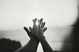 hands holding in front of sea