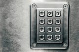 Keypad on silver metal door or wall.