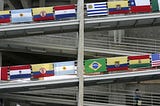 A woman walks on a ramp decorated with the flags of various countries of Latin America.