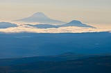 Photo of the mountains near the Cook Inlet in Alaska. Layers of blue-toned mountains with clouds lying low between them. Copyright 2024 David L. O’Hara, Ph.D.