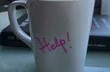 White mug with the words Help written in pink script