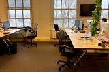 Four empty desks in an office building during winter