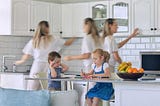 Mom busy in kitchen while kids do homework