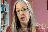 Helen Joyce is a white woman with long platinum hair and glasses. A still from the video interview.