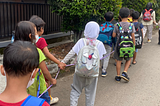 A picture of me and my preschool kids walking in a line. We are on a walk to the nearest park to have picnic.