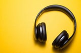 black headphones silhouetted against a bright yellow background