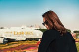 Woman in front of a floral version of the Emirates aircraft.