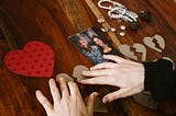 Person arranging photos and sentimental items on a table