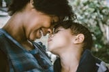 Mother and child smiling and touching noses with each other