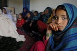 Young Afghan girl wearing a hijab stars at the camera during a community consultation session held by US military forces in a village in Afghanistan. Keywords: US withdrawal from Afghanistan, Afghan women, Afghan girls, foreign policy, War in Afghanistan.