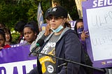 Nicole Brazil speaking at an outdoor rally.