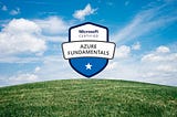 Shield logo that reads “Microsoft Certified Azure Fundamentals” on a blue sky background with a green, grassy hill.