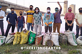 9 There Is No Earth B volunteers stand at Yamuna river bank with 11 bags of collected waste placed in front of them