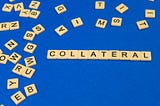 Scrabble words spelling “collateral” on blue cloth background