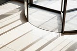A picture of a large revolving door, like the one you would find in an office building or department store.