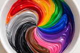 A swirl of liquid colors (red, orange, green, blue, purple, pink, brown, black, and silver) like paint in white bowl.