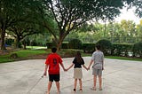 Photo of the author’s children at the park holding hands.