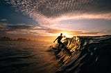 Nick Barringer, surfer, riding an ocean wave right at sunrise.
