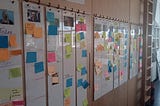 White boards with photos of each Cogapper on and post-it notes containing tasks