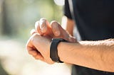 A man checks the time on his smartwatch.