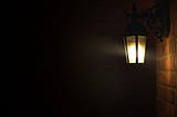 A lit porch light in a dark scene