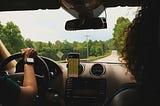 Woman looking out the front window of a car being driven by a man with a navigation app on a phone. women-only Uber, women-only rideshare, ride-sharing safety, Uber sexual assault statistics, driver background checks, safer rides for women, Uber safety policy, Lyft safety policy, gender and transportation safety