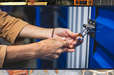 Human hands locking the garage entrance door to a self-storage unit.