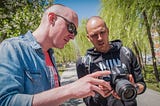 Photo of photography teacher working with student.