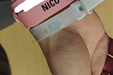 A pink NICU wrist band