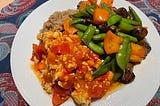 A delicous looking dish of tempeh marinara, sugar peas, mushrooms, sweet peppers and quinoa.