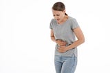 A woman experiencing stomach pain after eating what does not agree with her blood type.
