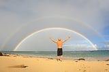 Author stares at ocean and a double rainbow.