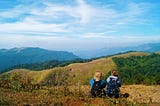 A scenic view of two young travel enthusiasts admiring the beauty of nature from the hills of Gavi in the Pathanamthitta district of Kerala.