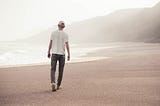 Young man walking alone on the beach